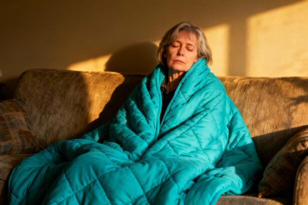 Femme adulte autiste en situation de burn-out sensoriel, assise sur un canapé avec une couverture lestée turquoise
