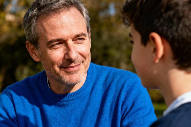 Homme de 50 ans portant un pull bleu vif échangeant un regard bienveillant dans un contexte de sensibilisation à l'autisme